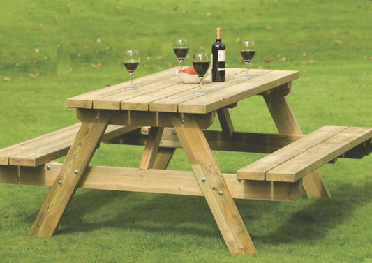 Wooden picnic table in a garden setting with tools on top